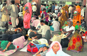 Passengers wait for trains at Haridwar railway station on Wednesday as services have been hit by flash floods.