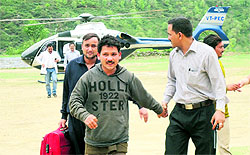 Stranded people evacuated by a helicopter and brought to Augustmuni helipad in Garhwal