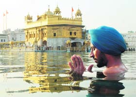 A devotee takes a holy dip in the sarover at the Golden Temple in Amritsar