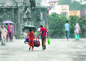 A couple rushes for cover as it pours on a hill station