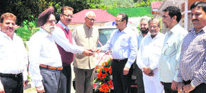 The chairman of the Federation of Associations of Tour Operators of Jammu, Rajesh Gupta, hands over the key of an ambulance to Amarnath shrine board CEO Navin K Choudhary in the presence of Governor NN Vohra. 