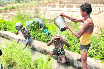 A man pours water on his friend to beat the heat in Jammu on Wednesday. Tribune photo: Anand Sharma