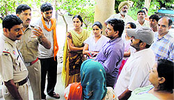 Police conducting inquiry at the residence where the couple lived; and (below) officials quiz the family members in Jalandhar on Wednesday