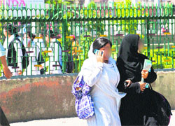 A student talks on a mobile phone while crossing a road in Srinagar on Wednesday. Tribune photo: Yawar Kabli 