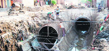 Municipal Corporation staff carry out the de-silting of the main water disposal passages at Gujjarpura in Amritsar on Wednesday.