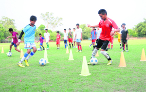 Local soccer player Sahil (red shirt) dribbles during trials for the Bajaj Allianz talent hunt soccer programme at Sector 17 in Chandigarh on Thursday. 
