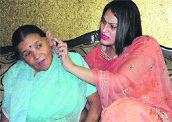 Gurbax Rawat, councillor, looks at her mother-in-law Shakambari's ear injury after the snatching incident. 