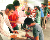 Students fill their forms at Government School, Sector 20, Chandigarh, on Thursday. T