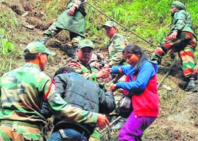 Army men shift stranded pilgrims from the Hemkunt Sahib area to a safe place in Chamoli on Thursday
