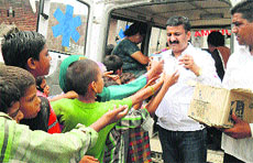 Red Cross office-bearers distribute food packets and drinking water in Lal Chappar village of Yamunanagar district on Thursday.