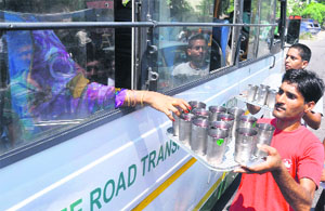 Devotees offer sweet water to bus passengers on the occasion of Nirjala Ekadashi near the Police Lines in Jammu on Thursday. 