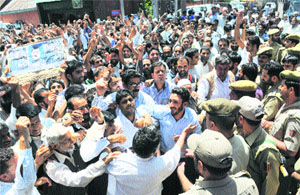 Policemen try to stop workers of the National Conference during a protest in Srinagar on Thursday. 
