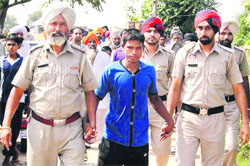 The accused in police custody at Sidhwan Khurd village on Thursday. A Tribune Photograph