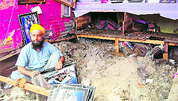 A shopkeeper in his devastated shop at Gobind Ghat on Thursday