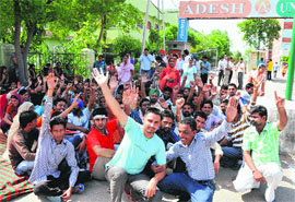 Class IV employees of the Adesh Hospital stage a protest in Bathinda on Friday. 