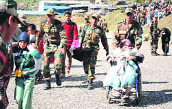 Army jawans take care of stranded pilgrims in Chamoli district on Friday. A Tribune photograph 