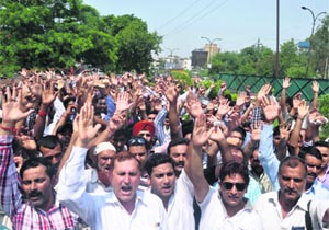 Members of the Jammu and Kashmir Employees Joint Consultative Committee protest outside the Divisional Commissioners office on Friday. 