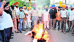 Sikh activists burn an effigy of a Mohali-based person for posting anti-religion comments on Facebook