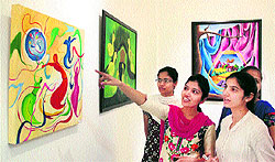 Visitors having a look at various paintings during an exhibition at Virsa Vihar in Jalandhar; and birds perched on a tree in the scorching summer heat
