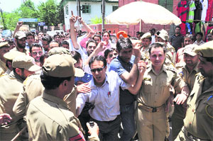 Police personnel detain protesters in Srinagar on Friday. 