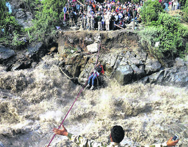 ITBP men rescue stranded pilgrims using a rope at Gobind Ghat in Chamoli district of Uttarakhand.  PTI