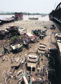 Flood-ravaged rickshaws lie at the bank of the Yamuna which began receding in New Delhi on Friday.  PTI 