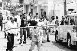 A man damages a vehicle during a clash between supporters of two Congress leaders near the Congress Bhavan in Ranchi on Friday.  PTI 