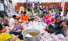 Volunteers of the Shiv Parwati Sewa Dal prepare food packets for Uttarakhand flood victims at the Satsang Bhawan, Sector 26, in Chandigarh on Saturday