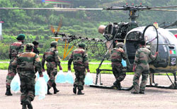 Army jawans load water in a helicopter at Gauchar in Rudraprayag on Saturday. Tribune photo: Vinod Pundir