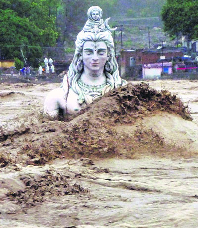  An idol of Lord Shiva in the Ganga at Rishikesh is washed by the raging waters. 