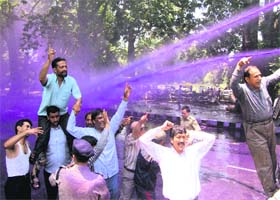 Police sprays coloured water on protesting government employees in Srinagar on Saturday