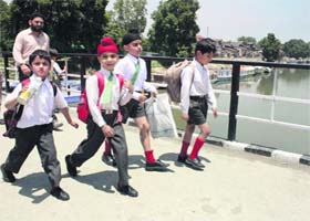 Schoolchildren walk at Budshah bridge in Srinagar on Saturday