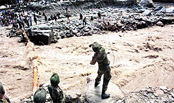 An Army jawan throws a rope across a river to help rescue pilgrims in Uttarakhand