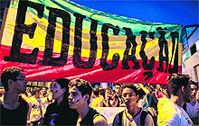 People march next to a banner reading 'Education' at a rally in Belo Horizonte, Brazil, on Friday