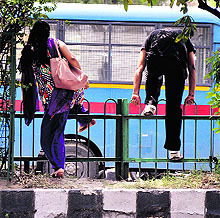 Commuters cross the railing outside the Government College for Women, Gandhi Nagar, in Jammu
