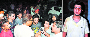 Police officials talk to people gathered outside the mobile showroom; Gaurav Sood (right) shows his injury marks.
