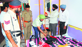 Police personnel investigating with the help of a dog squad press in a house that was burgled in Amritsar this month.