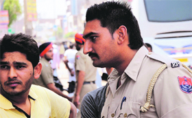 A policeman sports a swanky hair style not commensurate with the status of his job, at the Fauji Chowk in Bathinda.