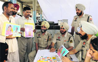 Relatives of missing pilgrims show their photographs to officials at a police help centre at the ISBT-43, Chandigarh. tribune photo:
