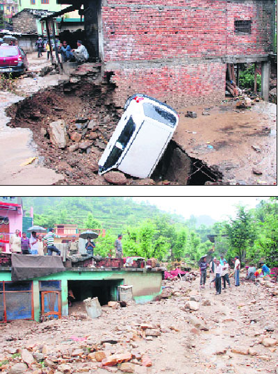 (Above) A car half buried in debris; and (below) mud and debris accumulate in the houses following a cloudburst at Paitnahi town of Pauri Garhwal district on Monday.