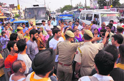 Residents of Nai Basti block Jammu-Srinagar Highway in protest against unscheduled power cuts in their locality in Jammu on Monday. Tribune Photo: Inderjeet Singh