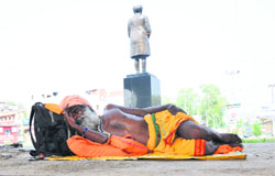 At peace with himself: A sadhu takes a nap at Dogra Chowk in Jammu on Monday. Tribune Photo: Inderjeet Singh