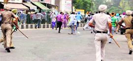 Police personnel chase away members of the Punjab Pharmacists Union who where holding a protest in support of their demands in Patiala on Monday.