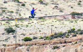 Daredevil Nik Wallenda gives a thumbs-up sign as he nears the end, after walking on a two-inch diameter steel cable rigged 1,400 feet across a quarter-mile deep remote section of the Grand Canyon near the Little Colorado River in Arizona (US) on Sunday.