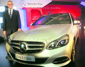 Mercedes-Benz India CEO Eberhard Kern poses with the new E-Class Mercedes-Benz car at its launch in New Delhi on Tuesday.