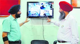 Senior Medical Officer Balbir Singh Dhillon (left) and SMO Ranjit Singh Buttar show the CCTV monitoring screen at the Civil Hospital in Amritsar on Wednesday