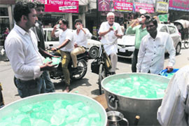 Volunteers of the Sahara Jan Sewa serve chilled water to visitors at Dhobi Bazaar on a hot afternoon. 