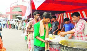 Social activists distribute food among evacuated pilgrims at a railway station relief aid camp in Haridwar on Wednesday