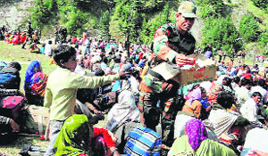 Army men distribute food packets among rescued flood-hit pilgrims on Wednesday.