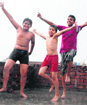  Children enjoy early morning showers in Amritsar on Thursday. 